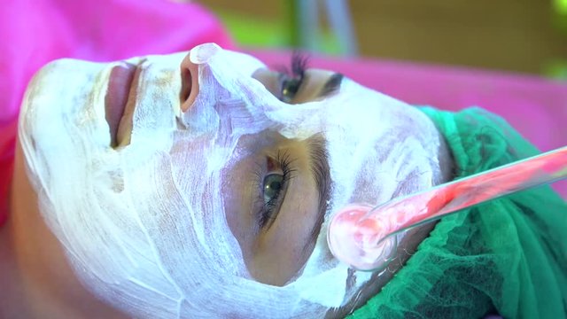 A young girl at a reception with a cosmetologist. Face cleaning. Darsonvalization.