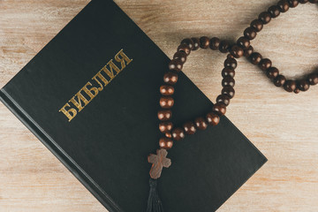 Fototapeta na wymiar Russian Bible and rosary on a rustic wooden table