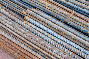 A number of steel rods or deformed rebars used in reinforced concrete with some corrosion. Diagonal pattern
