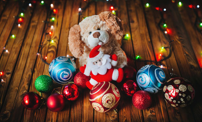 Santa Claus and the dog. Colorful Christmas balls and garland on a wooden background.
