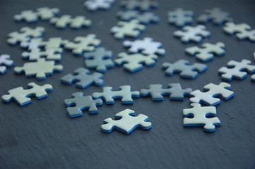 A lot of white and gray puzzles on a black background.