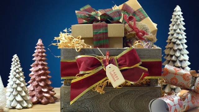 Large English style traditional Christmas hamper with paper wrapped gifts and food, close up panning shot.