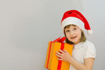 Christmas kid in Santa hat on white background received a gift.