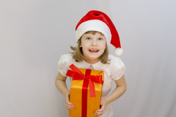 Christmas kid in Santa hat on white background received a gift.