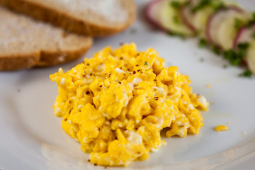 Scrambled eggs with toast, cucumber and radish
