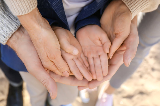 Grandparents with grandchild holding hands together