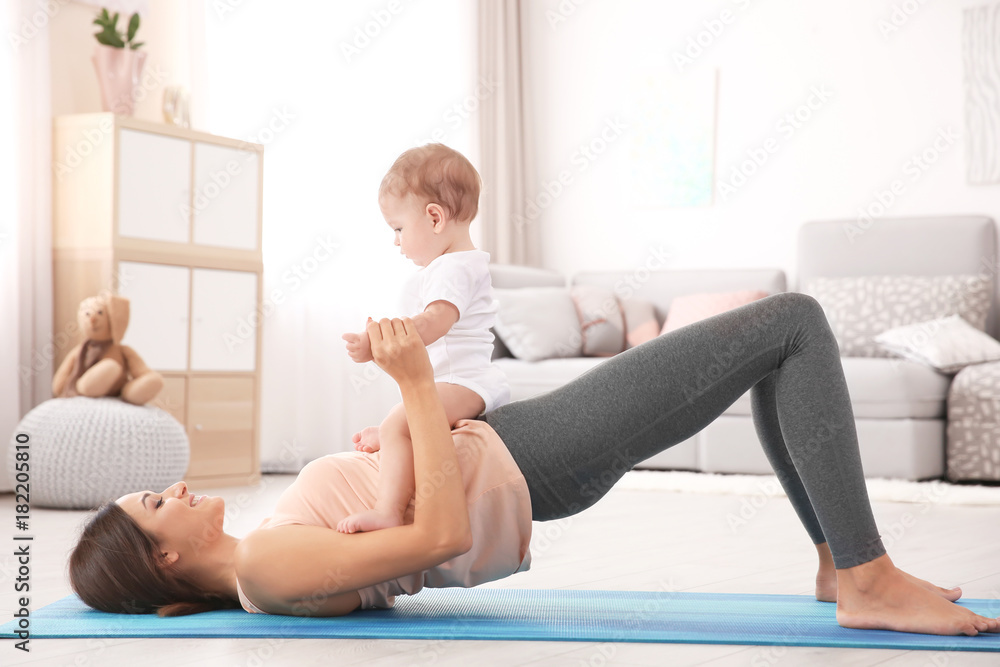 Canvas Prints Young mother doing yoga with baby at home