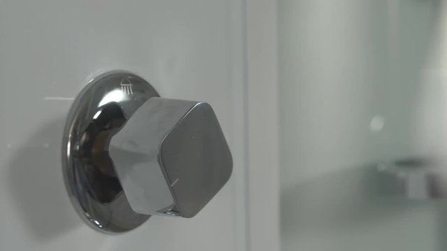 Hand turn on faucet shower cabin. Opening a water tap. Open valve shower
