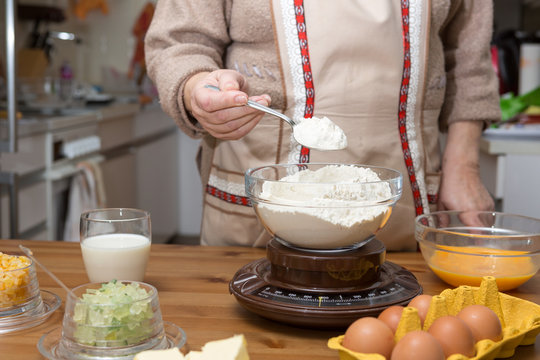 Oma wiegt das Mehl für die Kekse mit einer Lebensmittelwaage ab