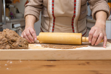 Hausfrau rollt den Teig mit einem Nudelholz aus, closeup