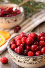 Fresh Cranberries in a bowl on wooden background, selective focus