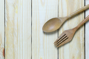 wooden spoon rests on a brown wood floor.