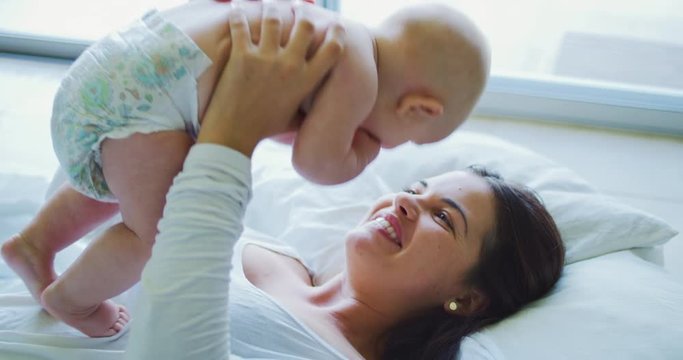 Mother playing with adroable cute happy baby
