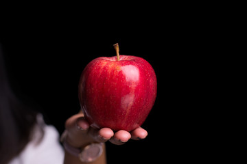 Woman holding red apple on isolate black background