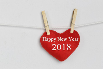 Red heart hanging on a rope and have happy new year text.