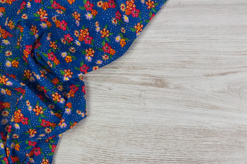 Floral pattern cloth napkin on empty wooden background.