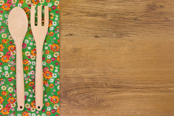 Set of kitchen utensils. Pattern flower cloth napkin on empty wooden background.