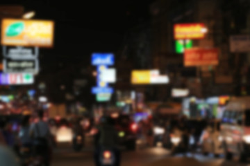 Blurry background of road with roaming cars at night.