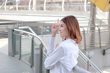 Fototapeta premium Candid shot of attractive young Asian secretary woman standing and smile at city with copy space background.Candid shot of attractive young Asian secretary woman standing and smile at city background.
