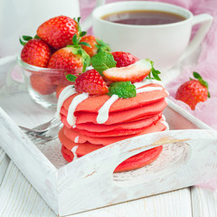 Stack of red velvet pancakes with yogurt and strawberry on on wooden tray, square