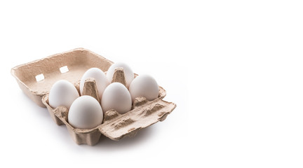 half dozen, six, white eggs in brown carton container with lid open on white background