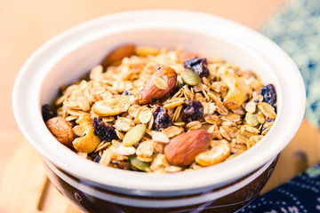 closed up of multi-grain cereal with dried fruits and nuts in an asian style bowl