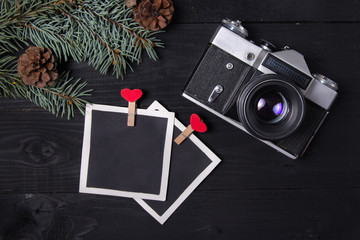 retro christmas background with vintage camera, fir tree, snow, gift boxes and blank photo with notebook and copy space. top view