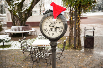 vintage old clock with the inscription Happy New Year 2018 and Santa Claus hat on them