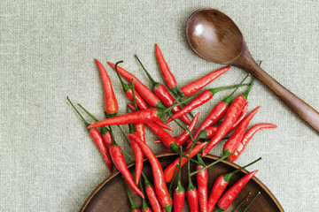 Red chili peppers scattered from flat plates on a tablecloth. Free space for text, view from above....