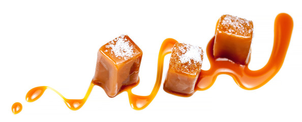 Homemade salted caramel pieces isolated on white background. Golden Butterscotch toffee candy caramels macro.