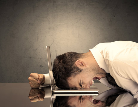 Frustrated businessman's head on keyboard