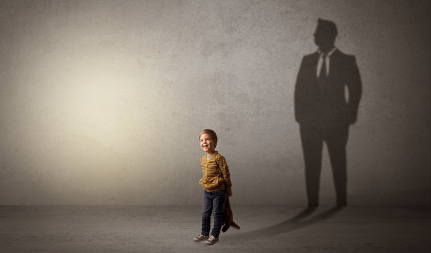 Little boy with businessman shadow