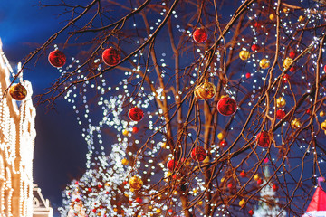 Streets of Moscow decorated for New Year and Christmas celebration. Tree with bright red and yellow balls. GUM (Main Department Store) building with light bulbs. Russia.