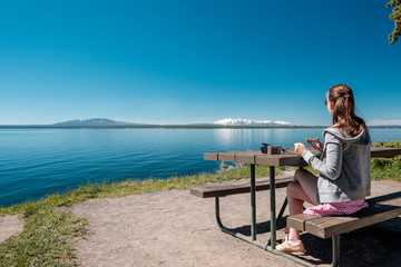 Fototapeta na wymiar Woman tourist having a breakfast by Yellowstone Lake