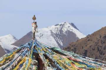 Tibetan landscape in China with prayer flags on foreground and mountains on background