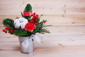 The composition of flowers and fir tree branches on wooden background