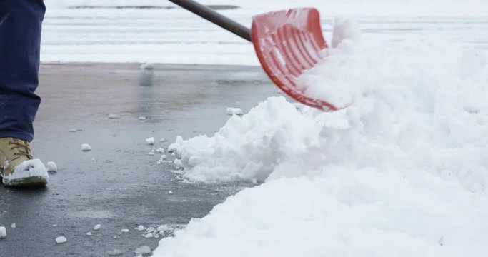Man shoveling snow off driveway - slow motion