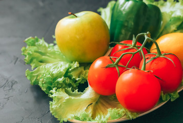 beautiful fresh fruits and vegetables on a black concrete background