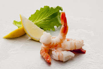 Steamed Jumbo headless shrimps with deli leaves and Lemon on white plate on white background 
