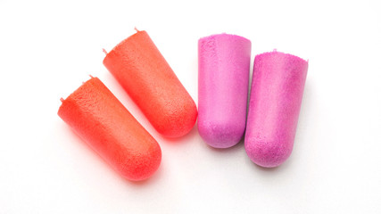 Red and violet earplugs on a white background.