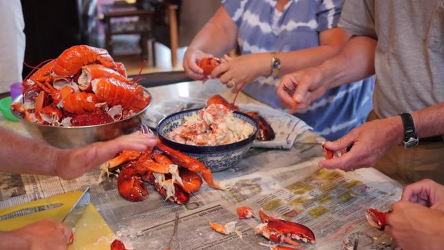 A family prepare fresh lobster for their dinner at home