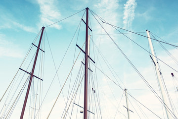 Masts of sailboat and blue sky, old filter