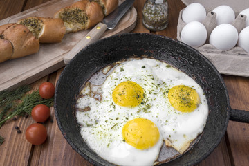 appetizing fried eggs in old frying pan