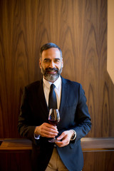 Handsome elegant businessman drinking red wine