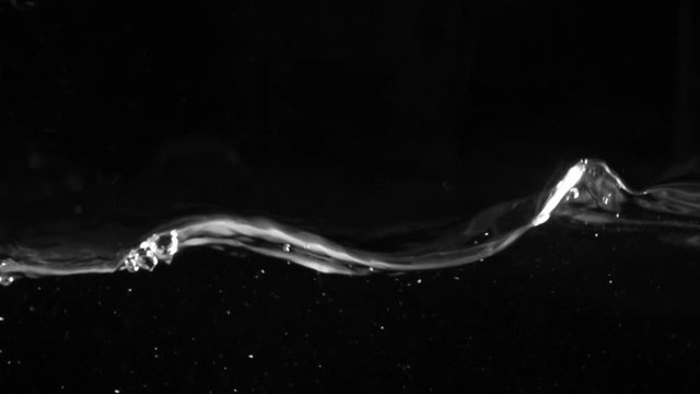 Slo-motion water against black drop