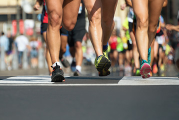 Marathon running in the light of evening,runners running on city road,detail on legs