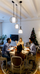 Young people celebrating New Year and drinking red wine