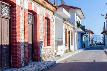Fototapeta na wymiar City street, house with stone wall and wooden window shutters