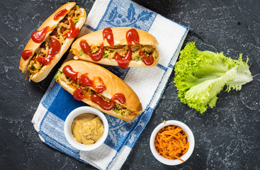 Hot dog with pickles and lettuce on concrete background