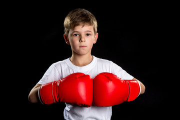 A confident boxer portrait with red boxing gloves together. The defend position portrait on the black background